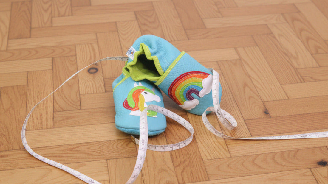 chaussons en cuir souple avec metre ruban le tout posé sur le parquet