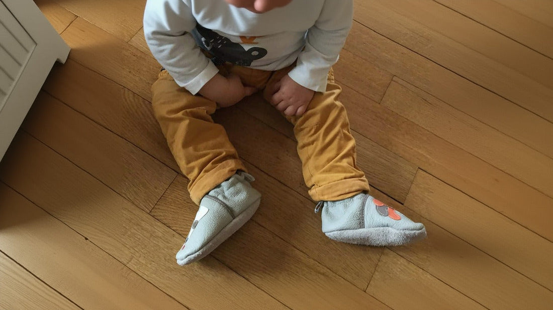 enfant assis sur parquet chaussons souples aux pieds