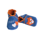 Chaussons en cuir souple artisanaux bleus pour bébé avec prénom personnalisé, renard orange sur un pied et cœur blanc sur l’autre.