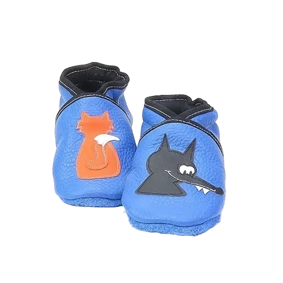 Chaussons en cuir souple artisanaux bleus pour bébé avec renard orange sur un pied et tête de loup noir sur l’autre.