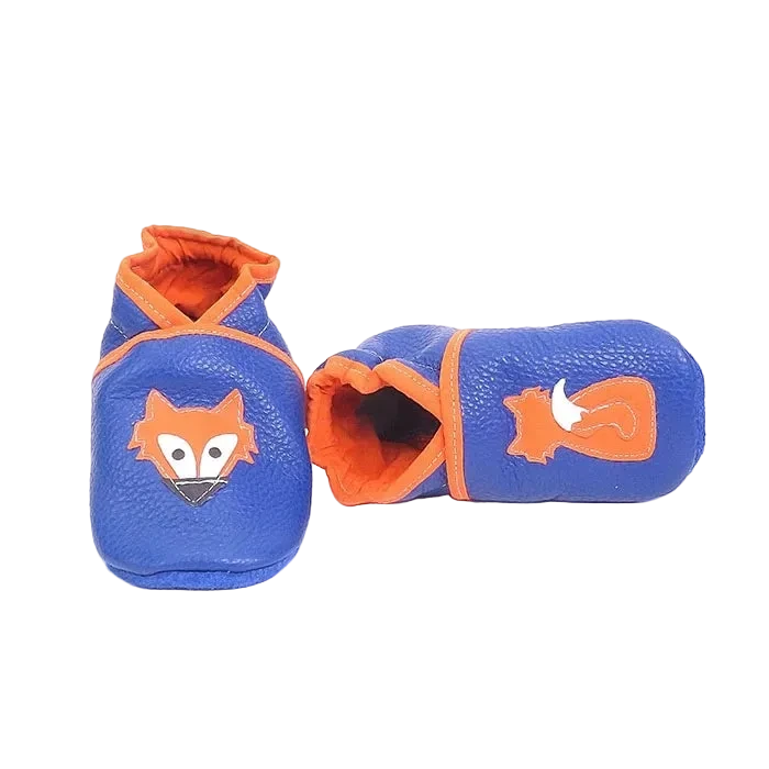 Chaussons en cuir souple artisanaux bleus pour enfant avec motif renard orange, vue inclinée avec un chausson allongé.