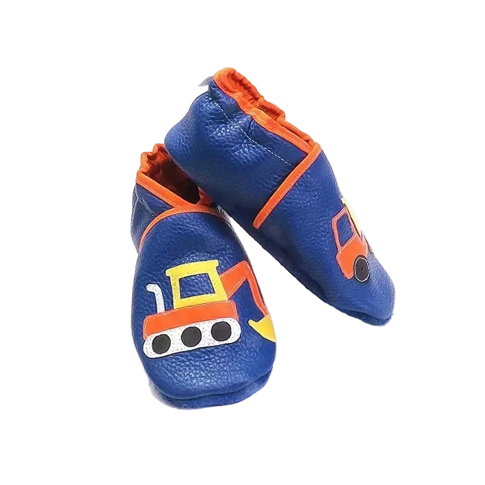 Chaussons en cuir souple artisanaux bleus pour enfant, vue en angle, avec motifs engins de chantier orange et jaune.