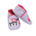 Chaussons en cuir souple artisanaux gris clair pour enfant, vue en angle, avec motifs engins de chantier rouges et noirs.