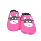 Chaussons en cuir souple artisanaux roses pour enfant avec tête de vache noire et blanche, finition élastiquée noire.