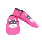 Chaussons en cuir souple artisanaux roses pour enfant, vue en angle, avec motif tête de vache noire et blanche, finitions noires.