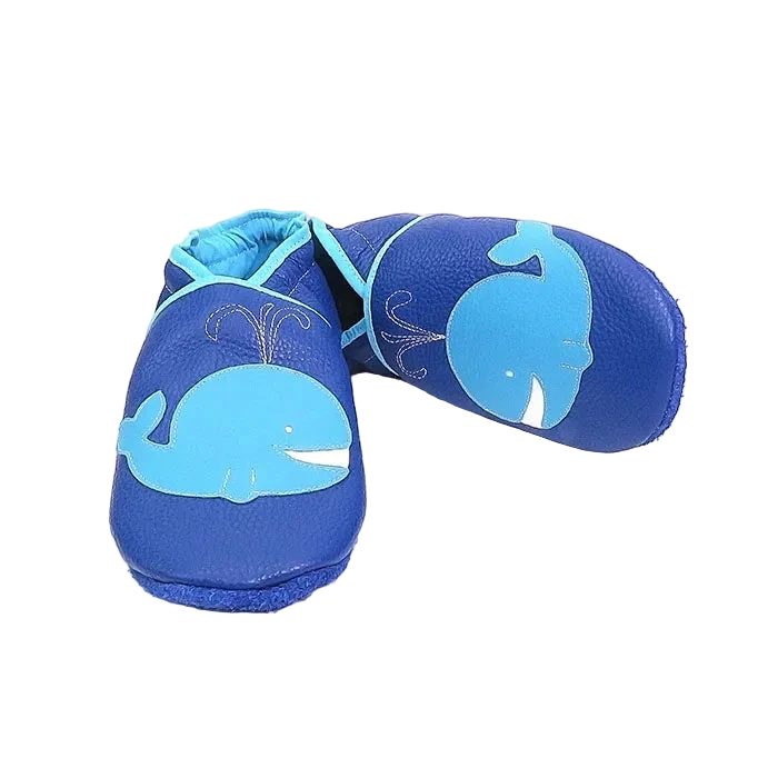 Chaussons bébé en cuir souple bleu motif baleine, vue croisée mettant en valeur la souplesse du cuir et les finitions contrastées bleu clair.