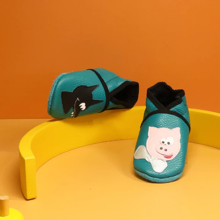 Détail du motif loup appliqué sur chausson bébé en cuir souple bleu canard.