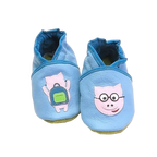 Chaussons bébé en cuir souple bleu avec cochon rose illustré et détail sac à dos, vue de face montrant les finitions contrastées.