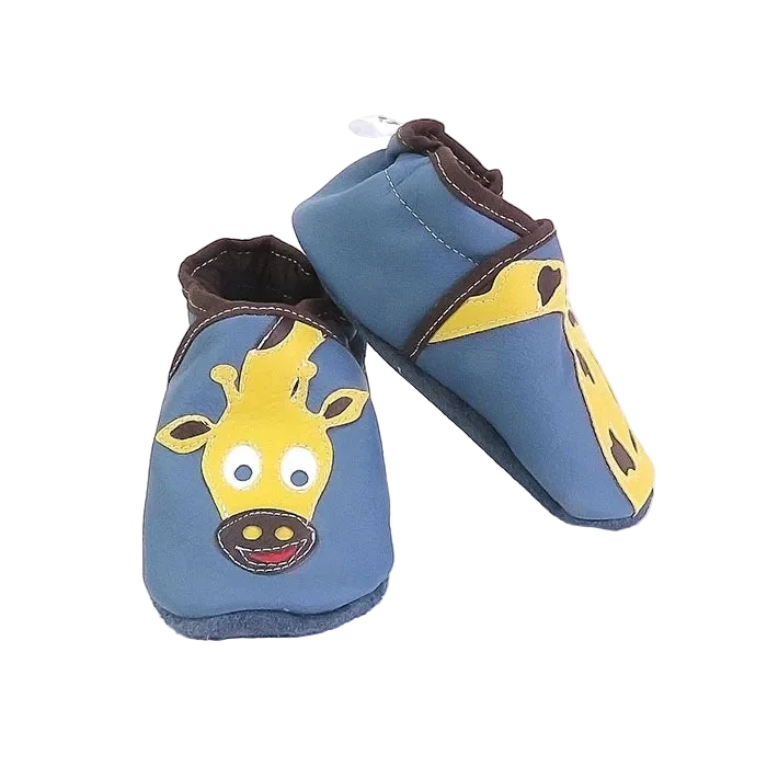 Chaussons bébé en cuir souple bleu motif girafe jaune, vue en biais mettant en valeur les appliqués et les finitions marron.