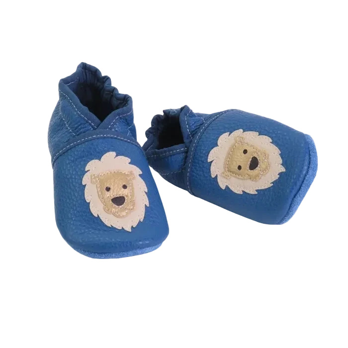 Chaussons en cuir souple pour bébé coloris bleu avec motif lion beige, vue croisée mettant en valeur la souplesse du cuir.