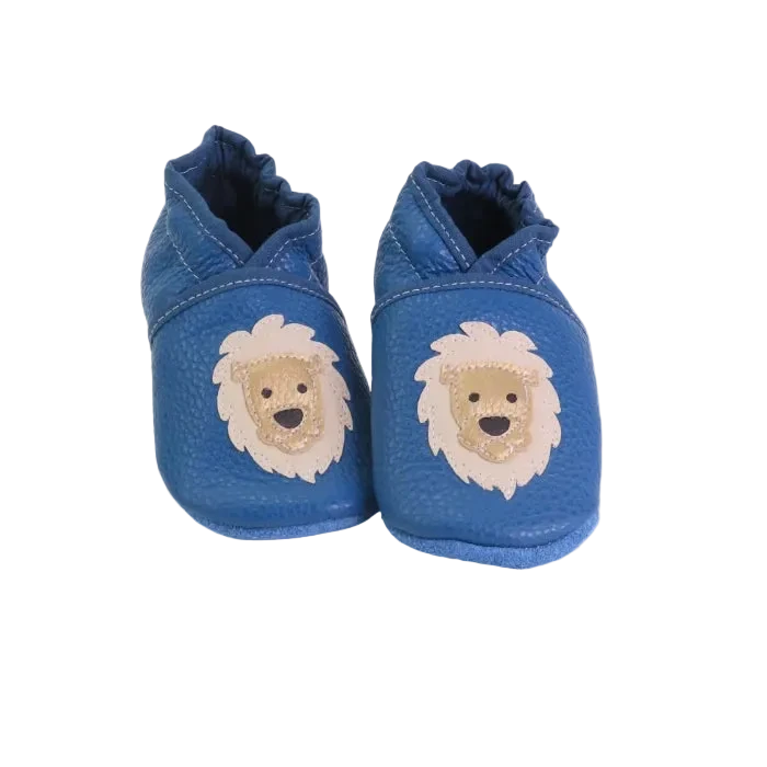 Chaussons bébé en cuir souple bleu avec tête de lion beige appliquée, fabrication artisanale française.