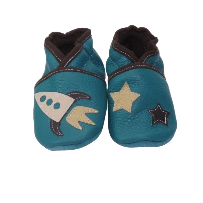 Chaussons en cuir souple pour bébé bleu pétrole avec motif fusée et étoiles contrastées, vue de face.