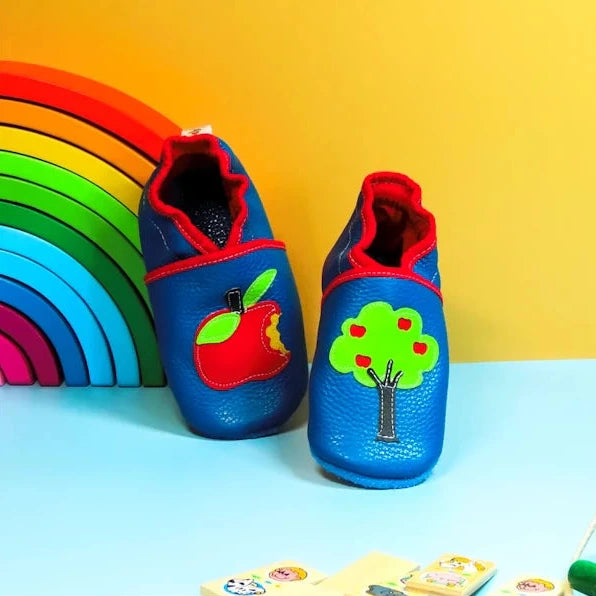 Chaussons en cuir souple bleu pour bébé avec motif pomme croquée et arbre décoratif, modèle coloré fait main.