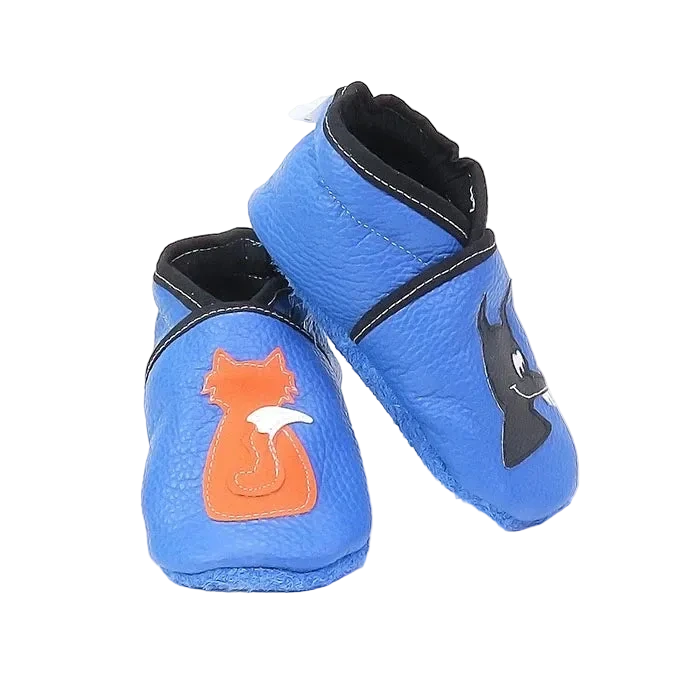 Chaussons en cuir souple artisanaux bleus pour bébé, vue en angle, avec motif renard orange et loup noir.