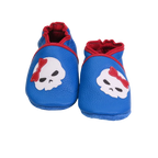 Chaussons bébé bleu avec tête de mort et nœud rouge en cuir souple.