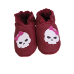 Chaussons bébé bordeaux en cuir souple avec tête de mort et nœud rose.