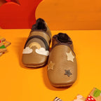 Chaussons bébé en cuir souple cappuccino avec motif arc-en-ciel et étoiles appliquées, fabrication artisanale.