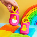 Chaussons bébé en cuir souple fuchsia avec poussin jaune sortant de sa coquille.