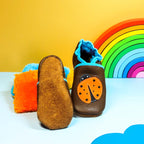 Chaussons en cuir souple marron pour bébé avec coccinelle décorative et semelle en cuir retourné antidérapante.
