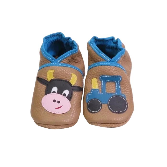 Chaussons bébé marron en cuir souple motif vache et tracteur.