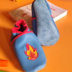 Chaussons en cuir souple pour bébé coloris bleu avec motif camion de pompier et flamme rouge, vue de face et dessous