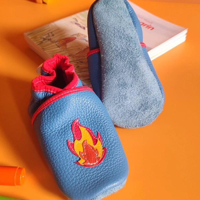 Chaussons en cuir souple pour bébé coloris bleu avec motif camion de pompier et flamme rouge, vue de face et dessous