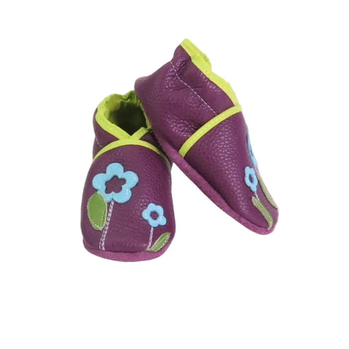 Chaussons bébé en cuir souple prune avec fleurs bleu clair et feuilles vertes, modèle artisanal coloré.