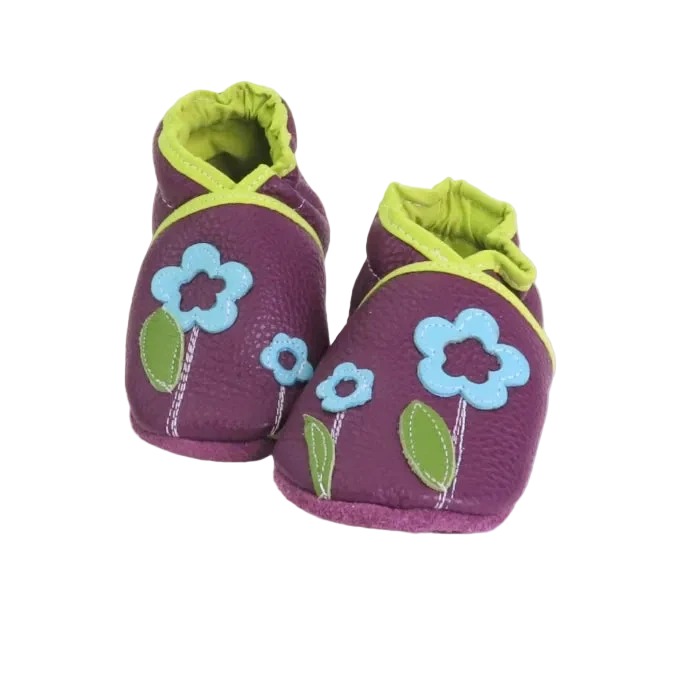 Chaussons en cuir souple prune pour bébé avec motif fleurs appliquées et détails contrastés vert anis.