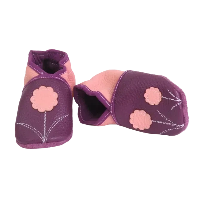 Chaussons en cuir souple pour bébé coloris prune et rose avec motif fleurs, vue croisée mettant en valeur les finitions.