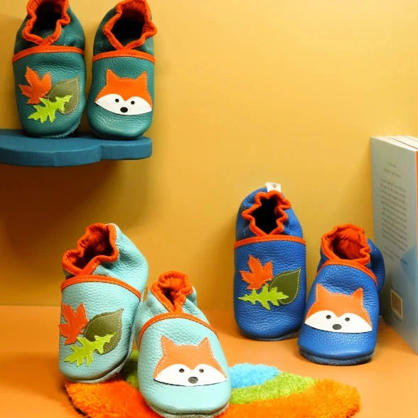 Chaussons bébé en cuir souple motif renard et feuilles, disponibles en plusieurs couleurs.