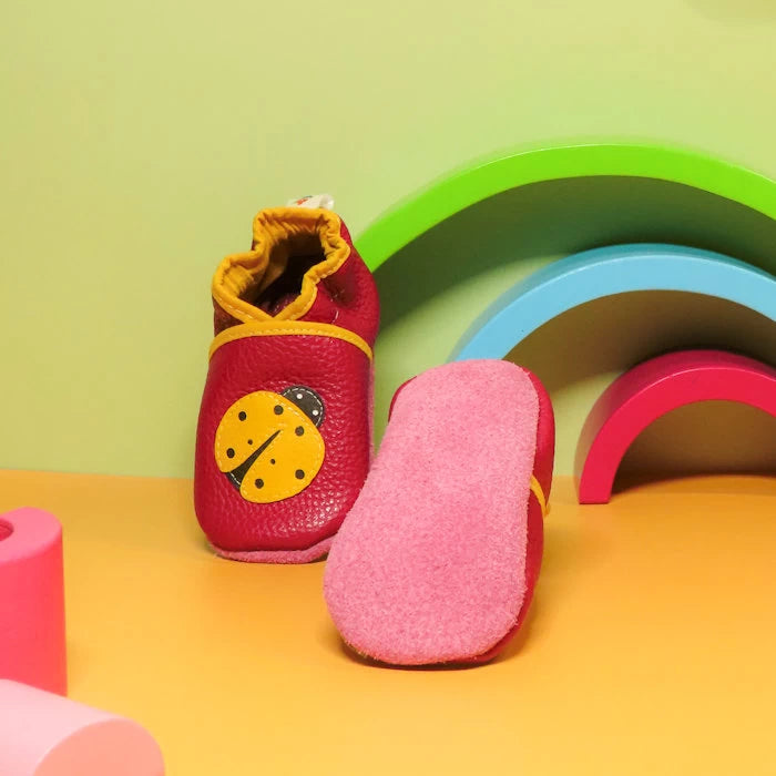 Chaussons bébé en cuir souple rose avec semelle en cuir retourné antidérapant, modèle coccinelle et fleurs.