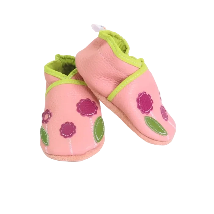 Chaussons bébé en cuir souple rose avec fleurs violettes et feuilles vertes appliquées, fabrication artisanale.