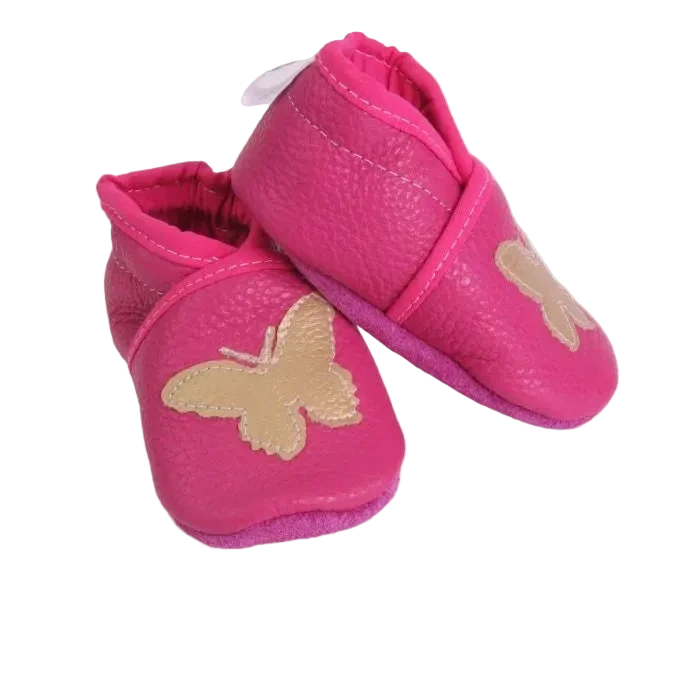 Chaussons bébé en cuir souple rose avec papillon beige, vue inclinée.
