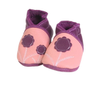 Chaussons bébé en cuir souple rose poudré et prune avec fleurs décoratives, vue inclinée.