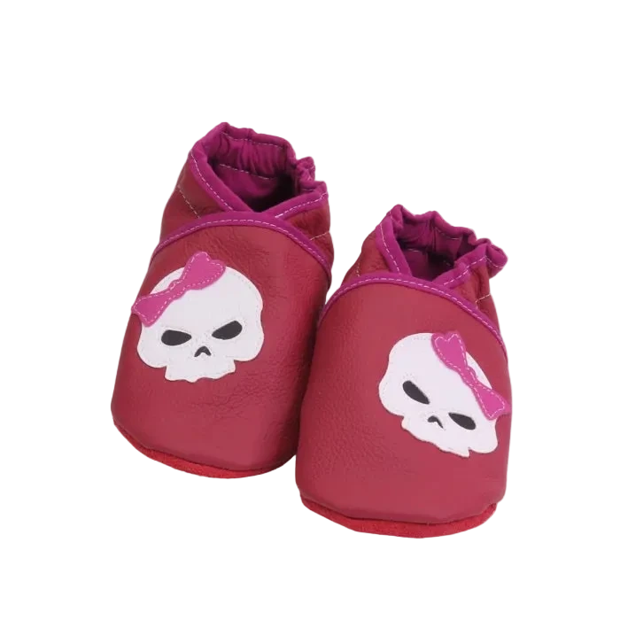 Chaussons bébé rose motif tête de mort avec nœud rose.