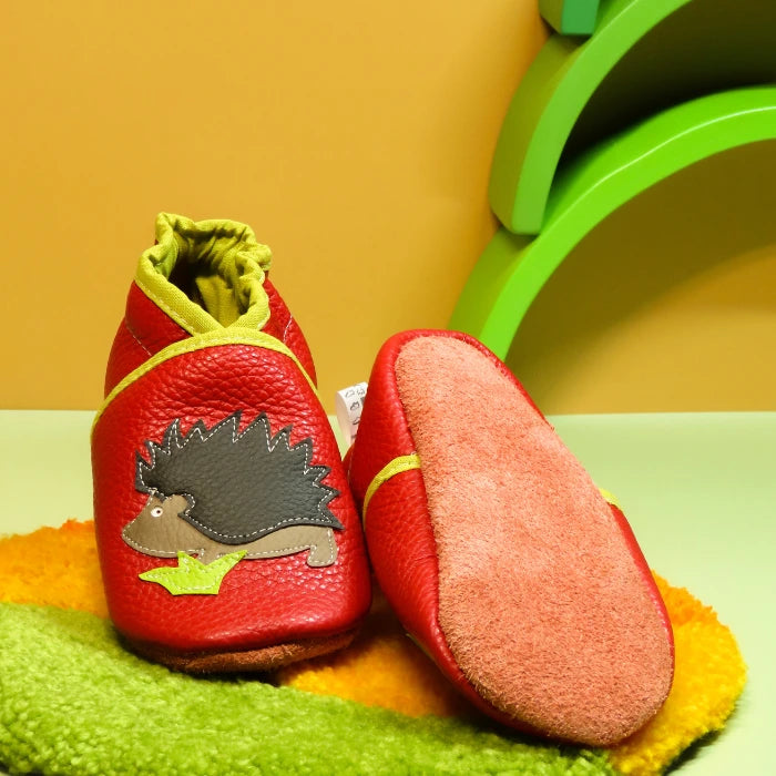 Chaussons bébé en cuir souple rouge motif hérisson, vue montrant la semelle en cuir retourné antidérapante.