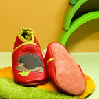Chaussons bébé en cuir souple rouge motif hérisson, vue montrant la semelle en cuir retourné antidérapante.