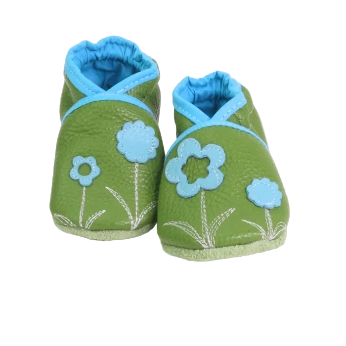 Chaussons bébé vert anis avec fleurs bleu clair appliquées.