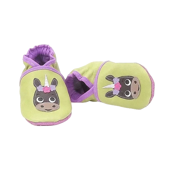 Chaussons bébé en cuir souple vert anis motif licorne avec détails floraux, vue croisée mettant en valeur les finitions violettes.