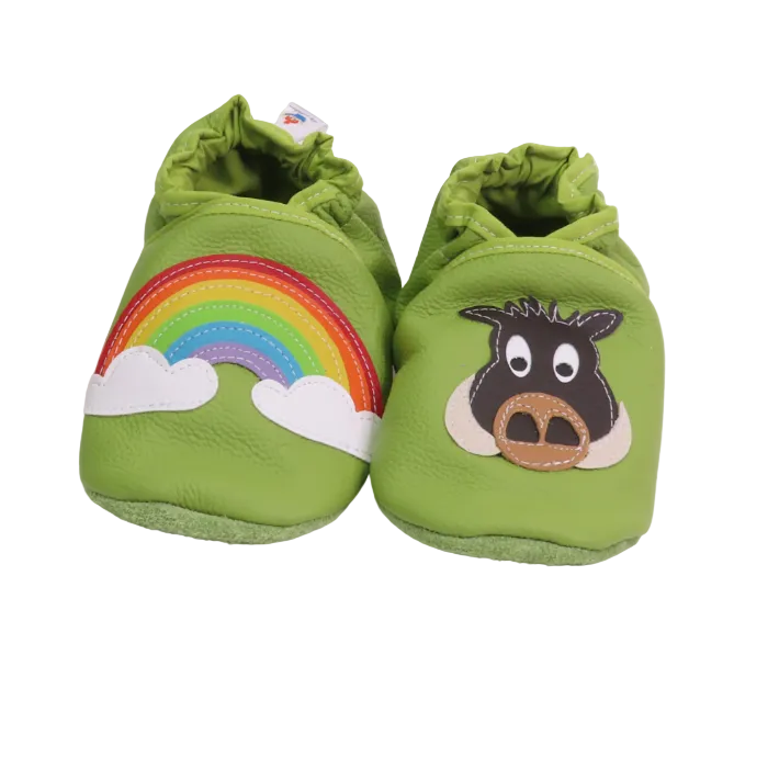 Chaussons bébé en cuir souple vert avec motif arc-en-ciel et tête de vache appliquée, fabrication artisanale.