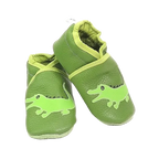 Chaussons bébé en cuir souple vert motif crocodile, vue en biais montrant les détails de l’appliqué et la texture du cuir.