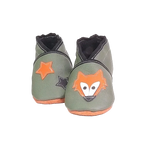 Chaussons en cuir souple artisanaux vert kaki pour bébé avec tête de renard orange sur un pied et étoiles orange et noire sur l’autre.