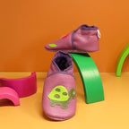 Chaussons bébé en cuir souple vieux rose avec tortue verte appliquée, vue de profil.