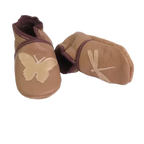 Chaussons en cuir souple artisanaux couleur camel pour enfant, vue en angle, avec papillon beige sur un pied et libellule beige sur l’autre, finitions marron.